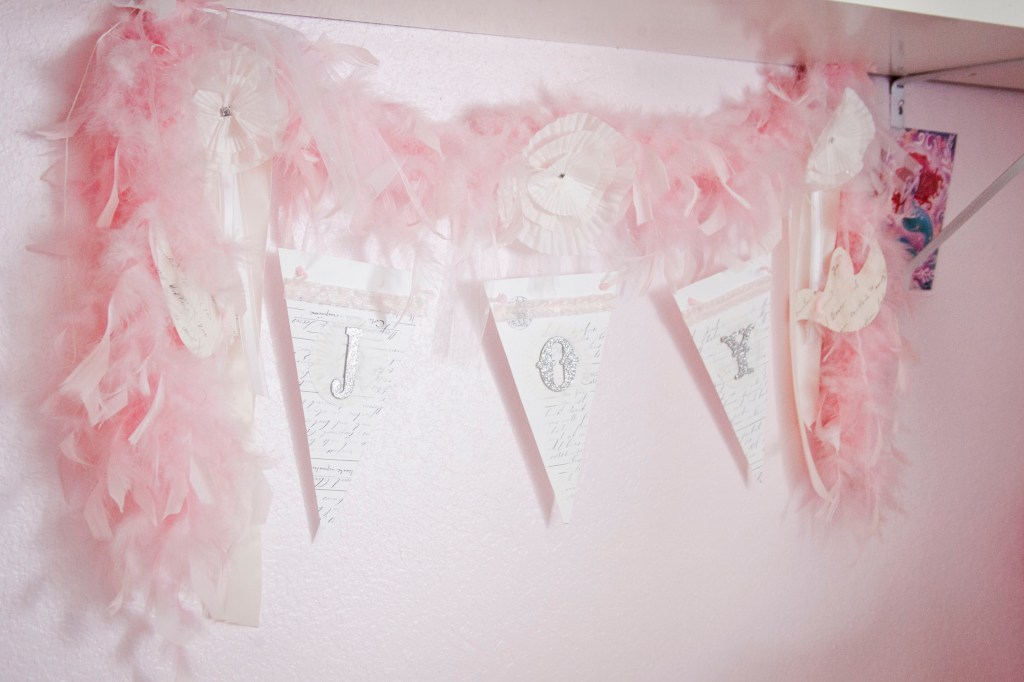 The very first thing you'd notice is the cute pinkness of everything. The centerpiece being this darling boa and JOY banner. 