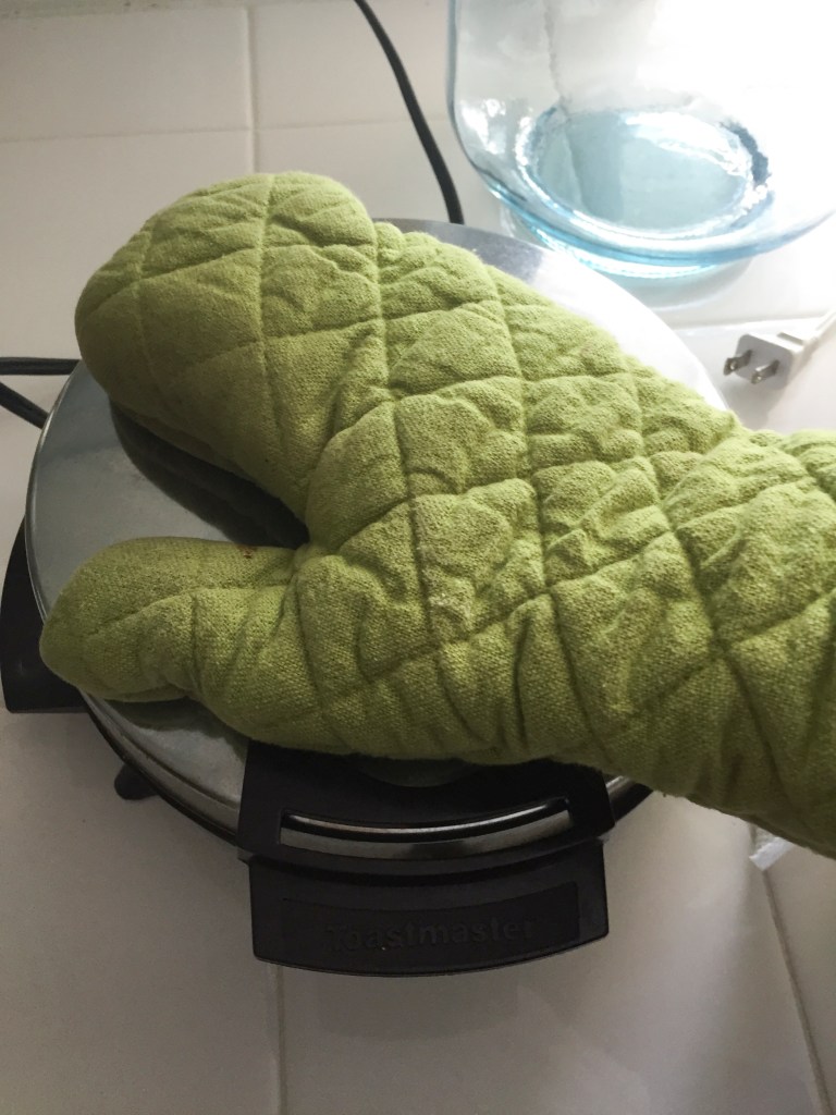 I placed the roll right in the middle of the iron and pushed the lid down. It was so fat I could barely get the lid closed, so I pushed it down with my "mitted" hand until the roll cooked enough to keep the shape, and the top no longer popped up. 