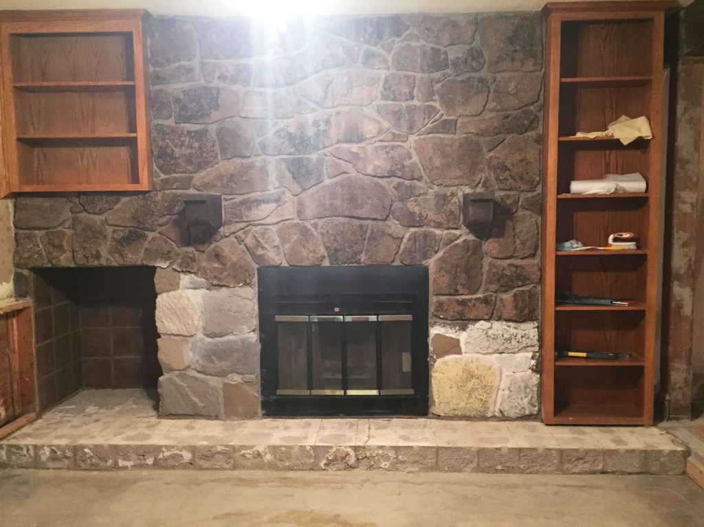 You can see on the bottom, there are a couple of test rock paintings going on. My plan was to fill in the mortar to update the rocks. I planned to paint each rock one of four colors and then stain them. They actually looked really cool, and we liked the ones on the left. Since we did that, we've voted to just remove all the rock in the house. I feel so liberated saying goodbye to it. At least I tried to make it work. You can also see the mantle is gone and so is the tile. We save everything we can that could in anyway be used again. 